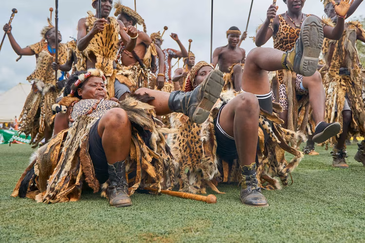 Warriors, adorned in traditional animal skins and wielding spears and shields, perform energetic dances that echo the martial traditions of their ancestors. (Image by Justin Kunda for Nkwazi Magazine).