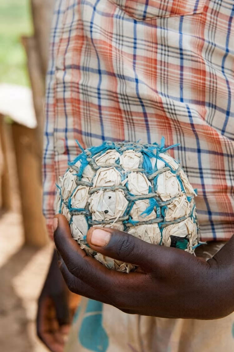 Layer upon layer of discarded shopping plastic bags were packed together and wrapped tightly with string until something resembling a football emerged. (Image courtesy of Wayne HUTCHINSON via Alamy).