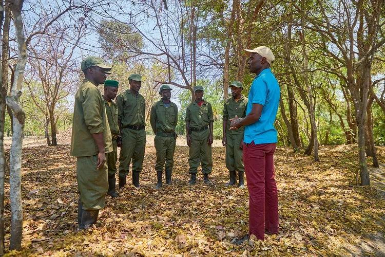 Wilson Kapumuna (right) addresses the Kafunfula Community Camp security patrol team. (Image by Nkwazi/Justine Kunda).