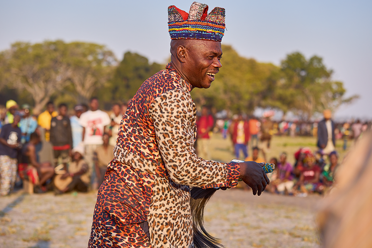 Leader of the Chota cha Chokwe Cultural Troupe reacts to the sounds of the friction drums  being played. (Image by Nkwazi/Justine Kunda).