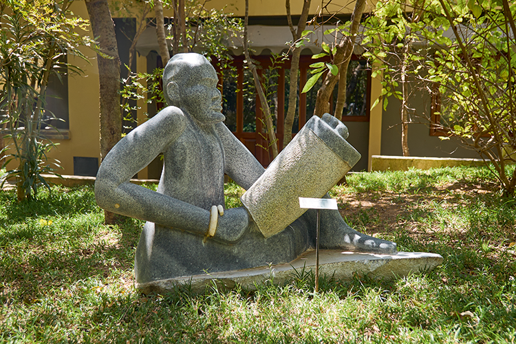 A garden sculpture depicting a man playing the Tonga speaking drum in front of the conference centre (Image by Nkwazi/Justine Kunda).