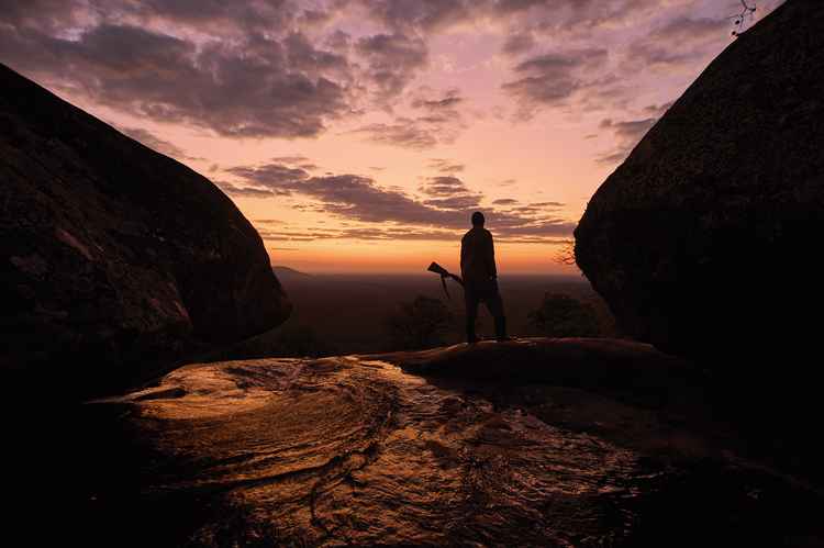 Moses, our guide, stands above the river next to Quentin’s Place as the sun rises, (image by Nkwazi/Adriaan De La Rey).