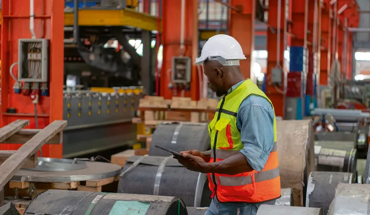 Man checking stock of metal sheets. (Image by Freepik).