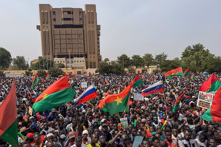 Supporters wave Russian and Burkina Faso flags at a rally in support of Traore. (Image by AFP via Getty Images).